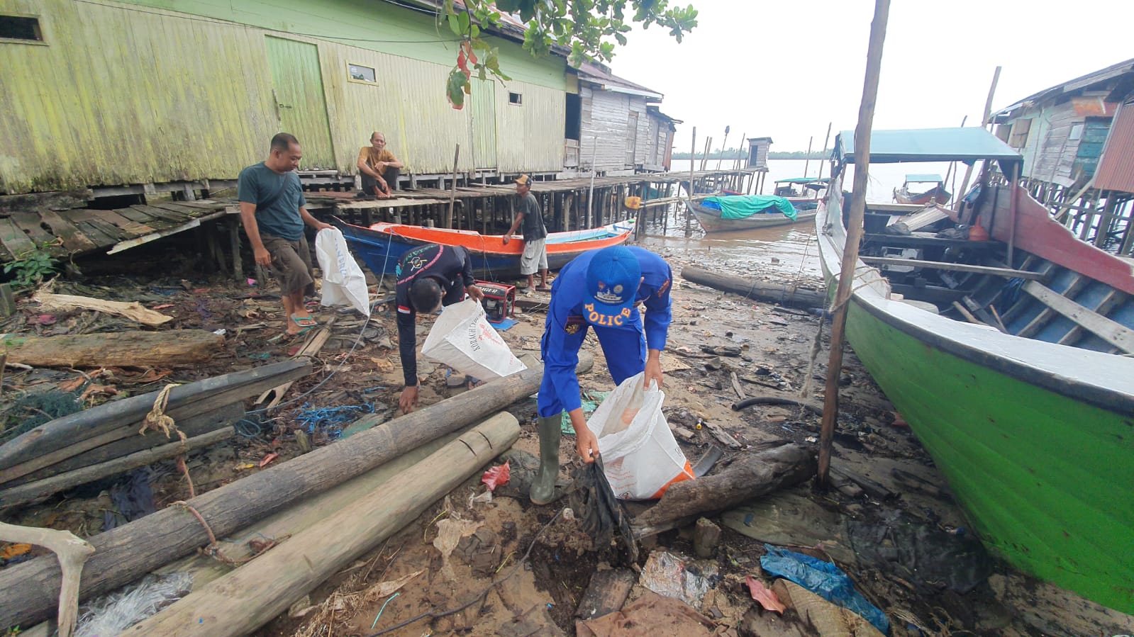 Personel Ditpolairud Polda Kalteng Mengajak Masyarakat Pegatan Melaksanakan Gerakan Indonesia Asri Bersihkan Sampah Di Persisir Pantai
