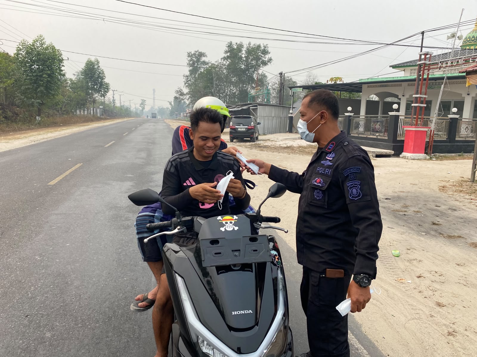 Satbrimob Polda Kalteng Bagikan Masker kepada Masyarakat di Tengah Kabut Asap